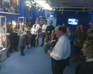 BADC members past and present watch on as Bryan cuts the cake